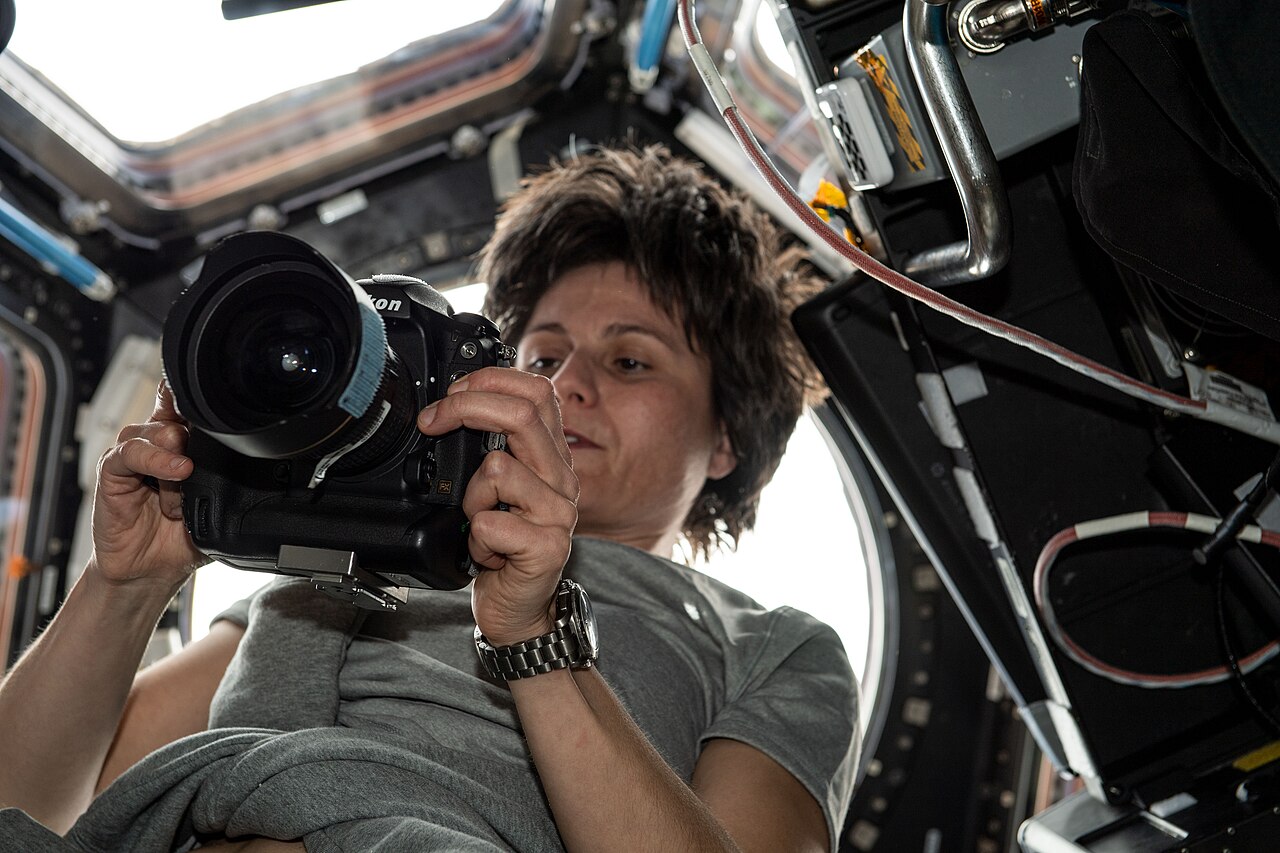 Samantha Cristoforetti checks a camera in the seven-window Cupola, an important Earth-observation location on the ISS