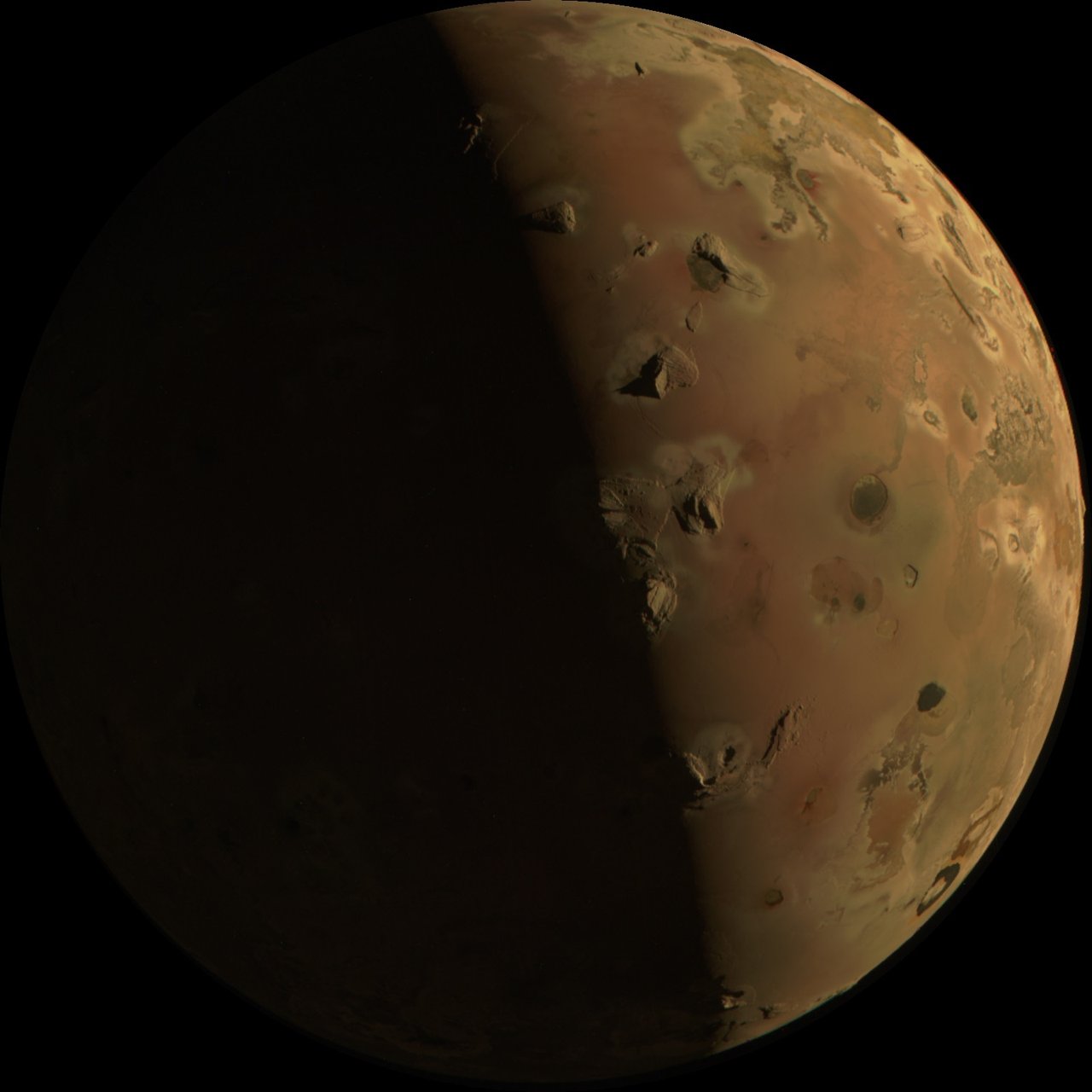 Junos Aufnahme von Io vom 30. Dezember 2023 aus rund 2.840 km Entfernung, mit der Tag-Nacht-Grenze über vulkanischem Gelände